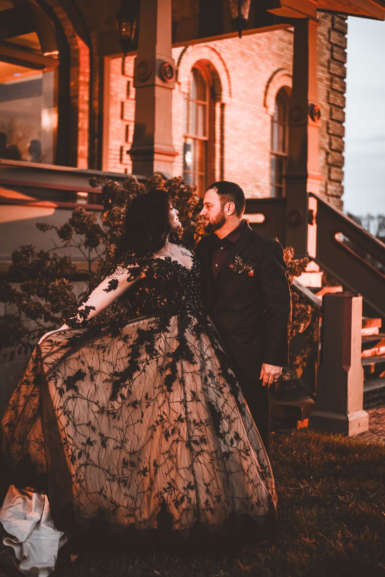 A romantic moment captured outside a historic building with ornate architecture.