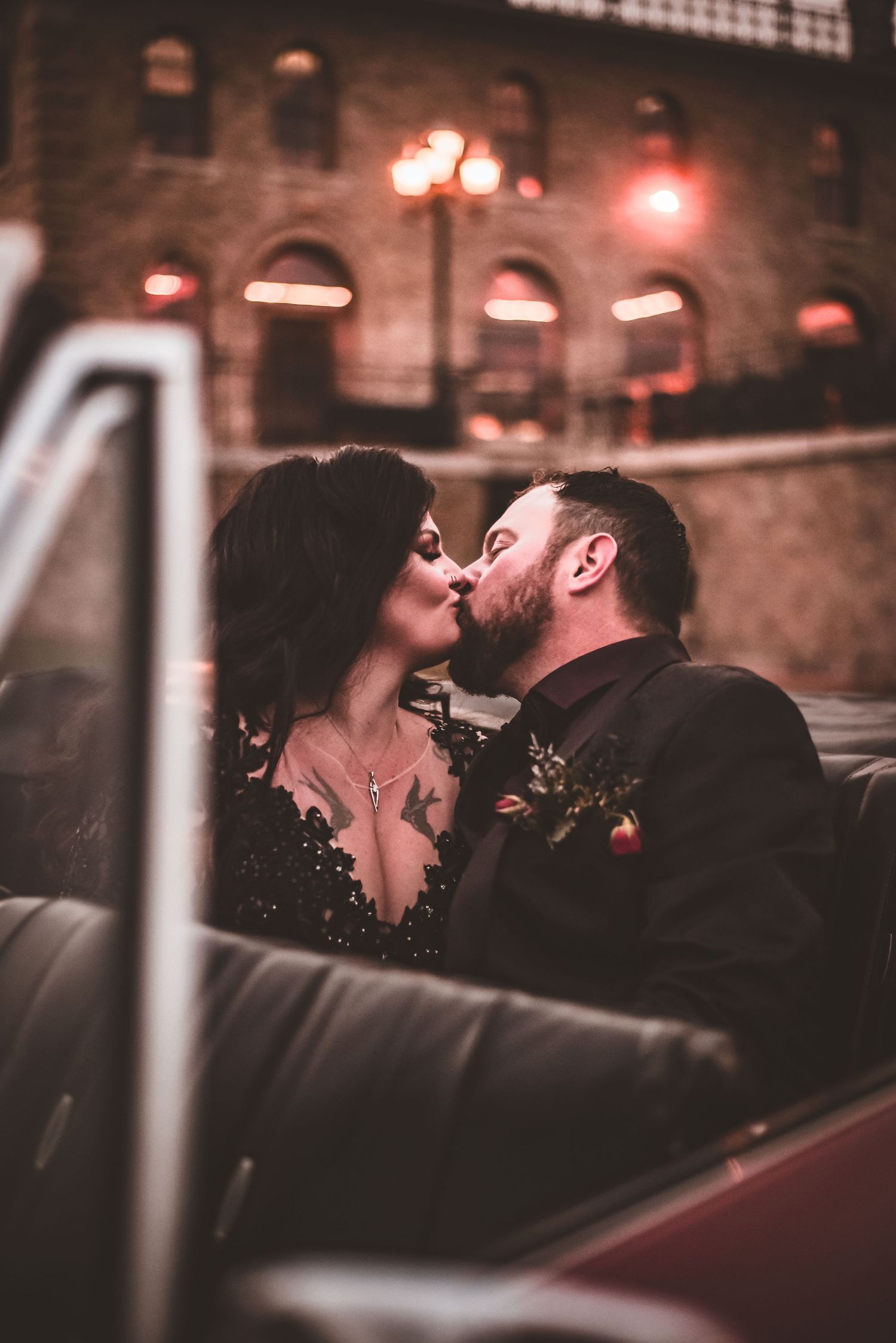 A romantic evening scene in a classic car with historic architecture in the background.