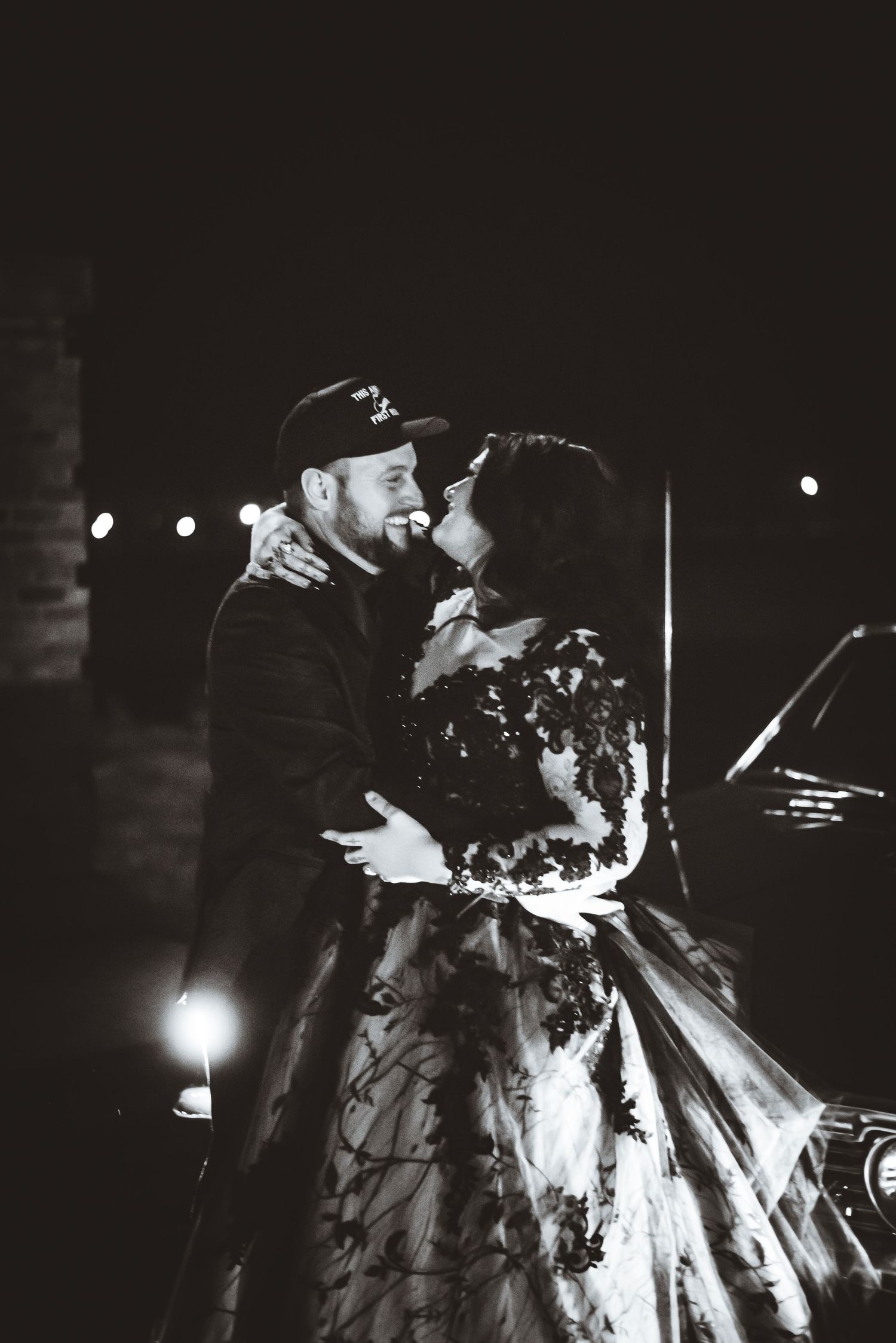 Black and white image of a romantic moment in formal attire at night.