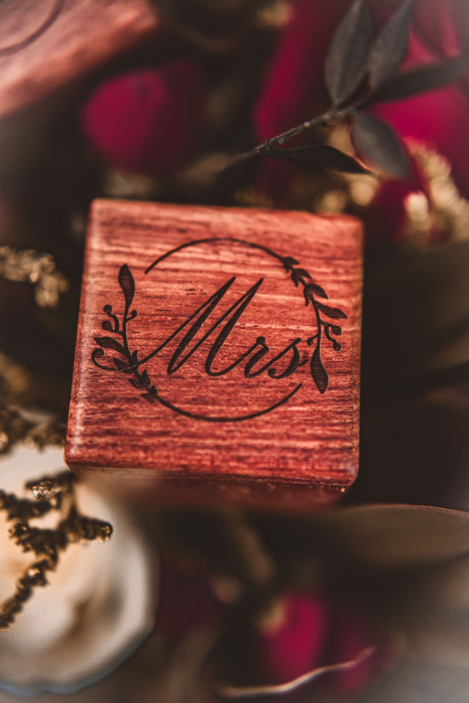 Detailed shot of a wooden ring box with Mrs text engraved in elegant script.