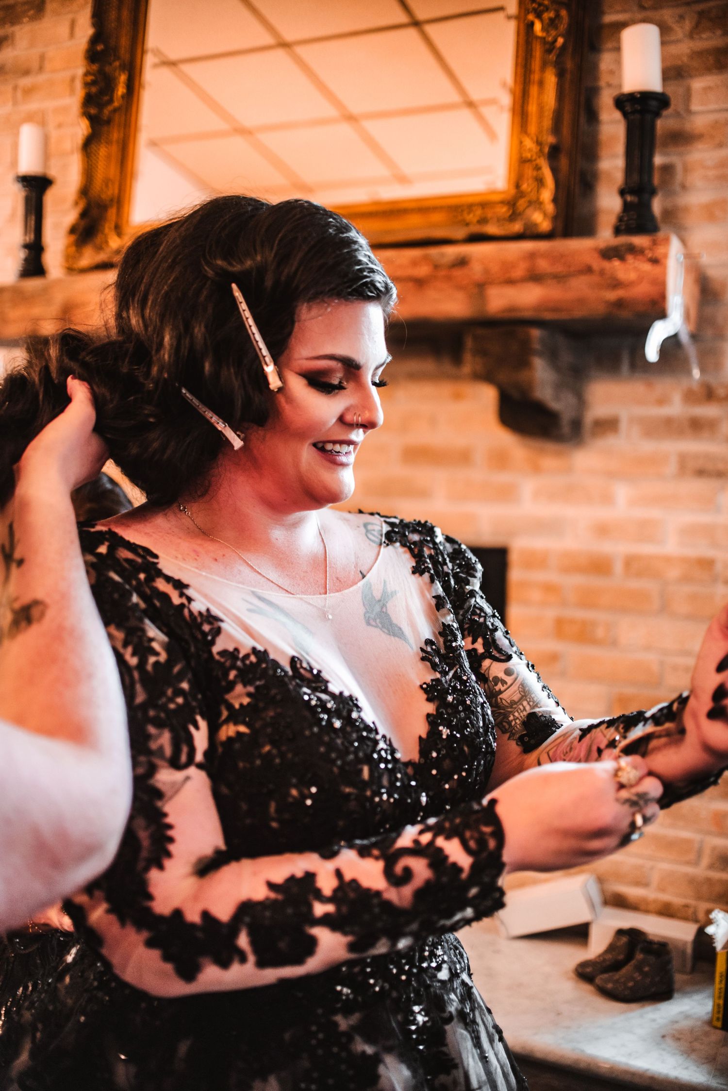 Close-up shot of someone wearing an elegant black lace dress during wedding preparations.