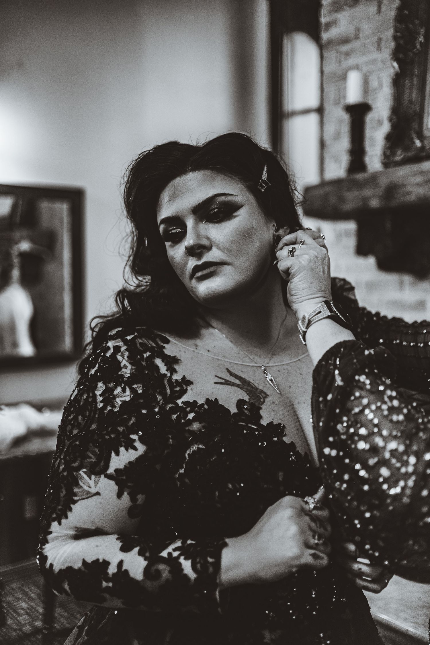 Dramatic black and white portrait showing intricate details of a black lace formal dress.