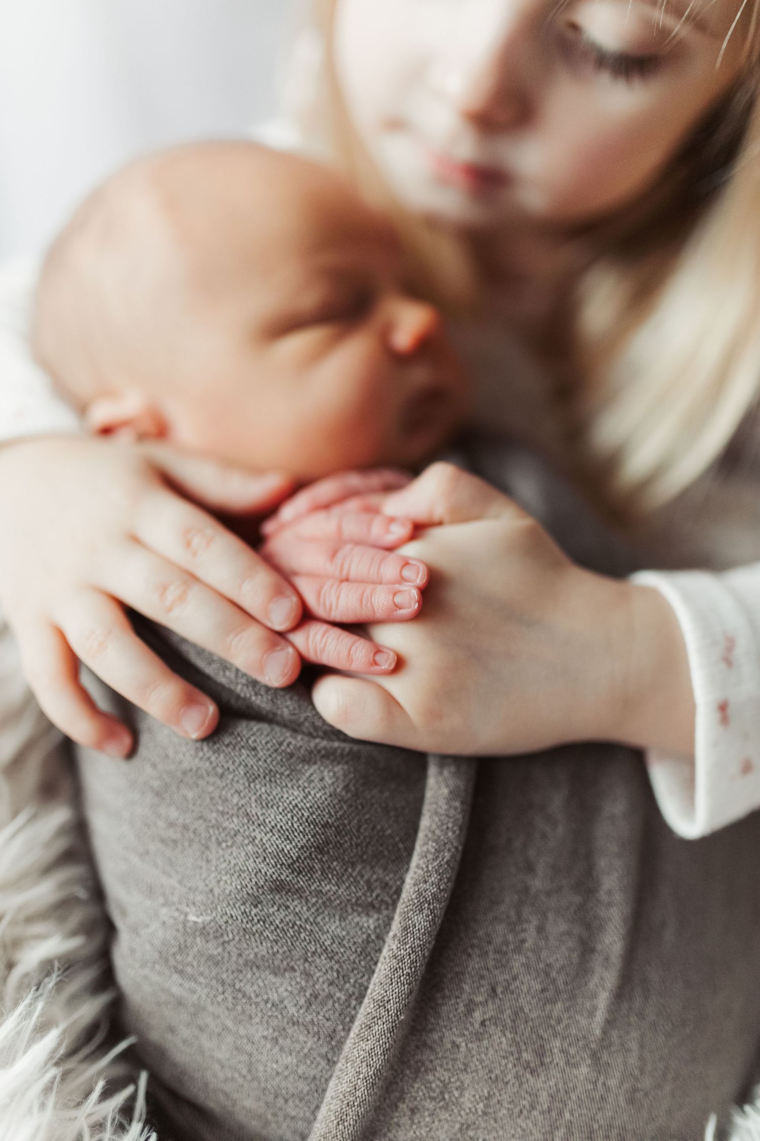 Close-up of tiny baby hands resting on grey fabric. Photographer. Hull. East Yorkshire. Photography