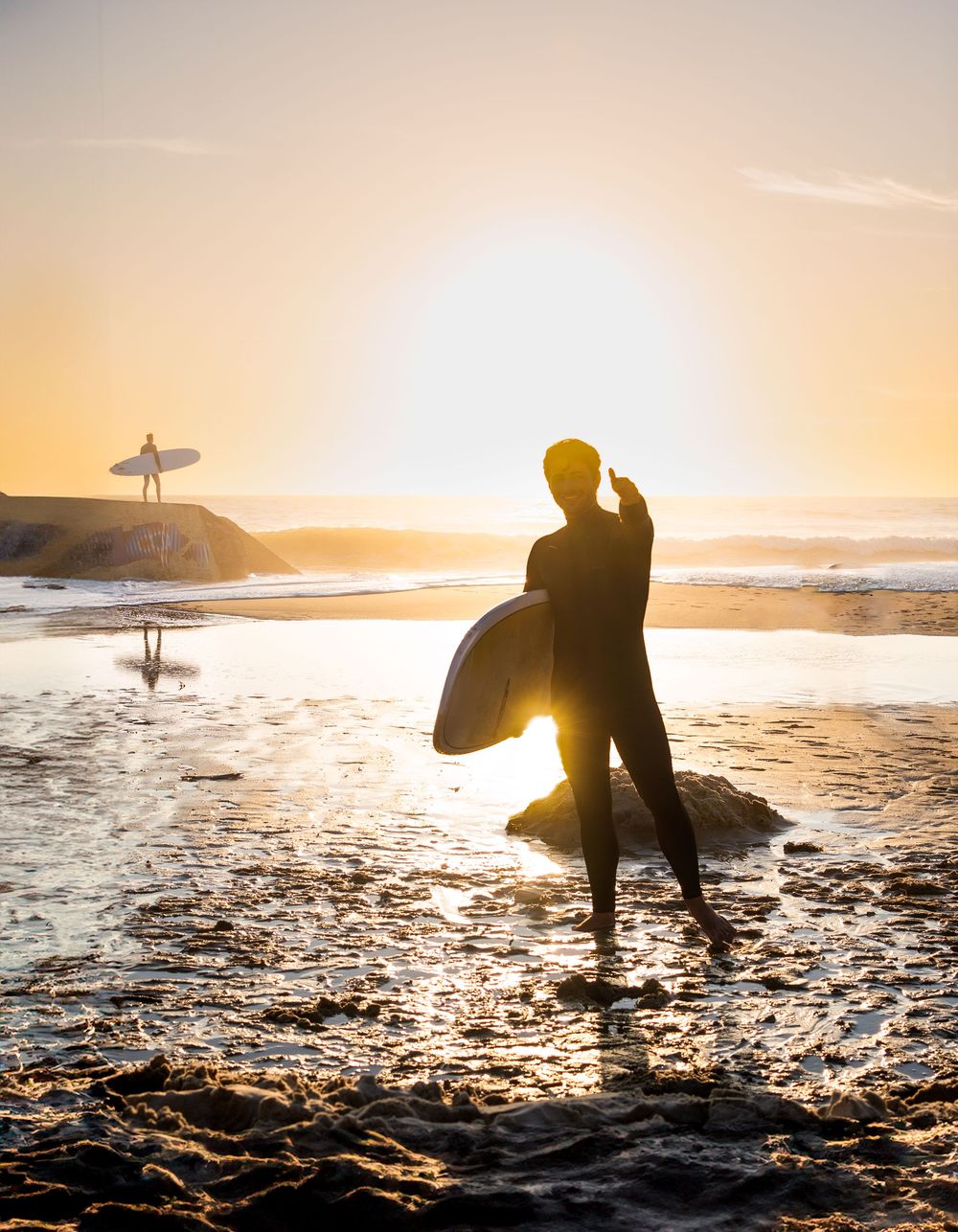 Un surfeur au coucher de soleil sur une plage de l'océan atlantique au Pin Sec