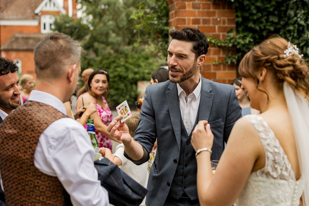 Wedding guests mingle and socialize during an outdoor reception at a brick venue on a sunny afternoon.