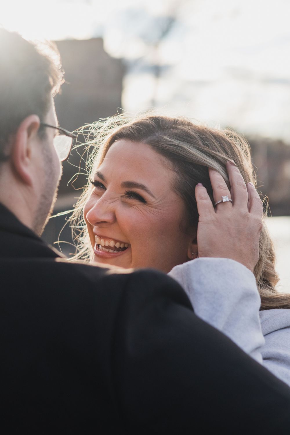 Sunlit portrait of a joyful couple sharing a romantic moment outdoors.