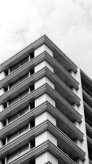 Modern apartment building exterior with geometric patterns and angular balconies in black and white.