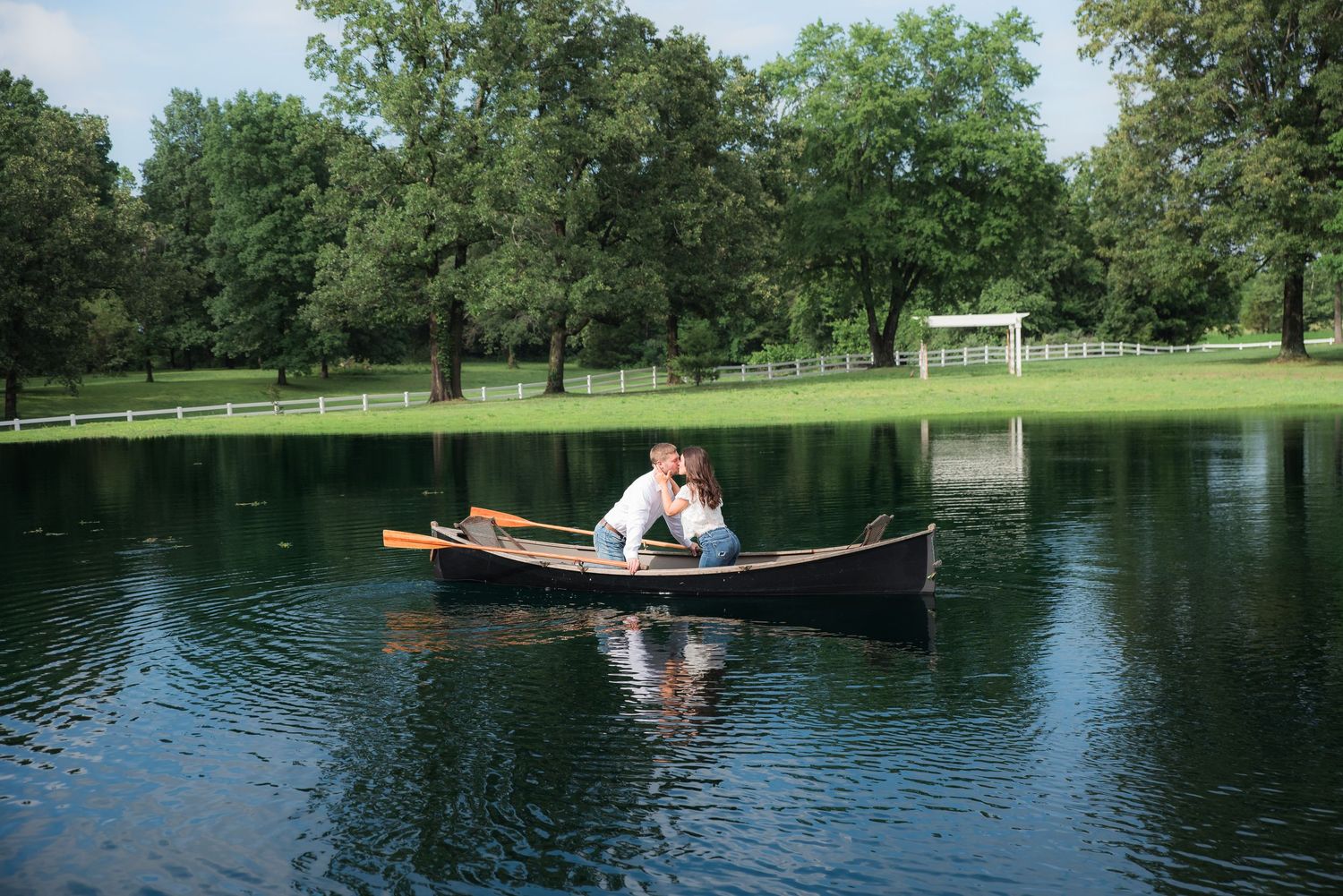 An engaged couple floating in a canoe in the pond at Whippoorwill Manor in Mayfield, KY.