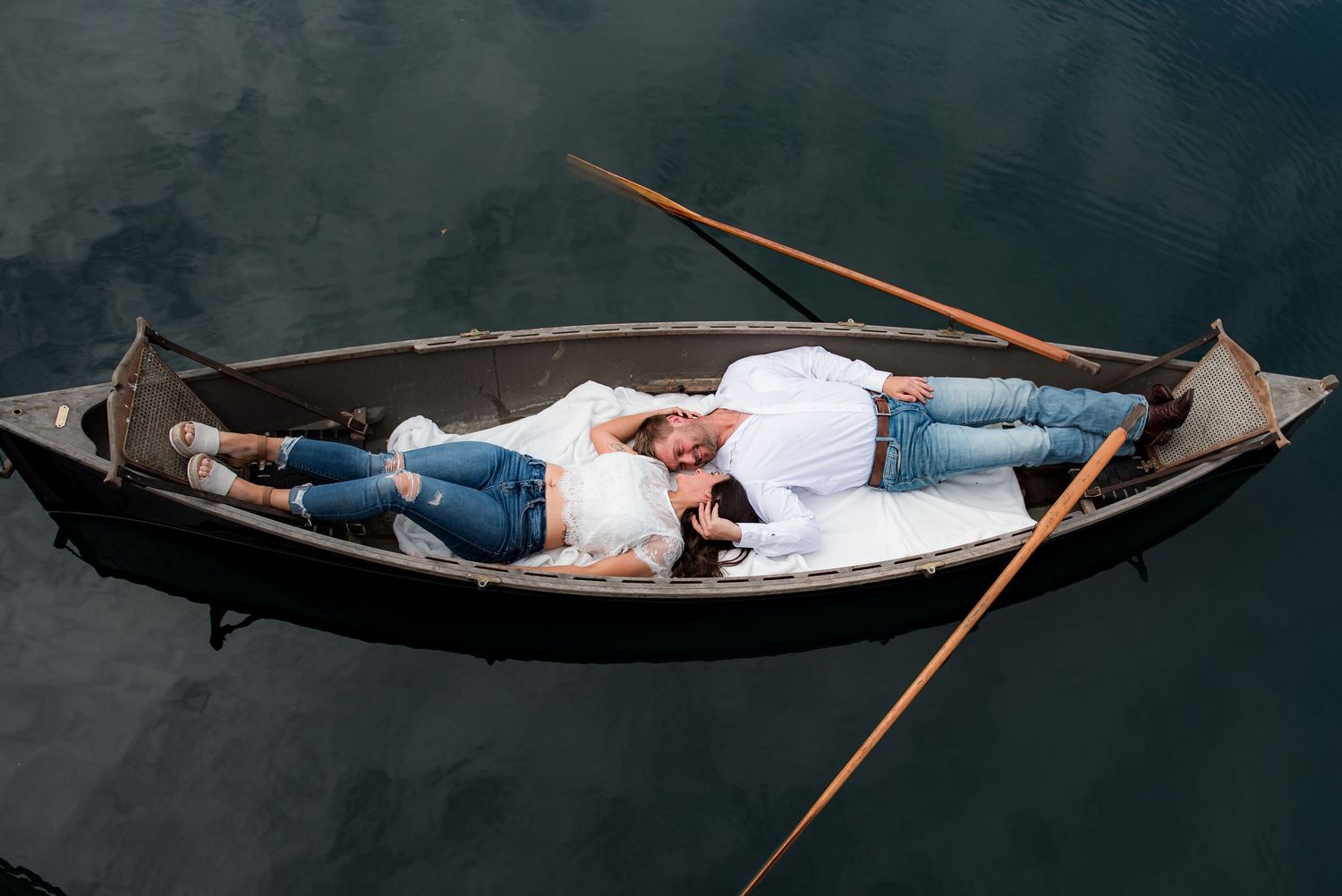 An engaged couple laying down in a canoe in the pond at Whippoorwill Manor in Mayfield, KY.