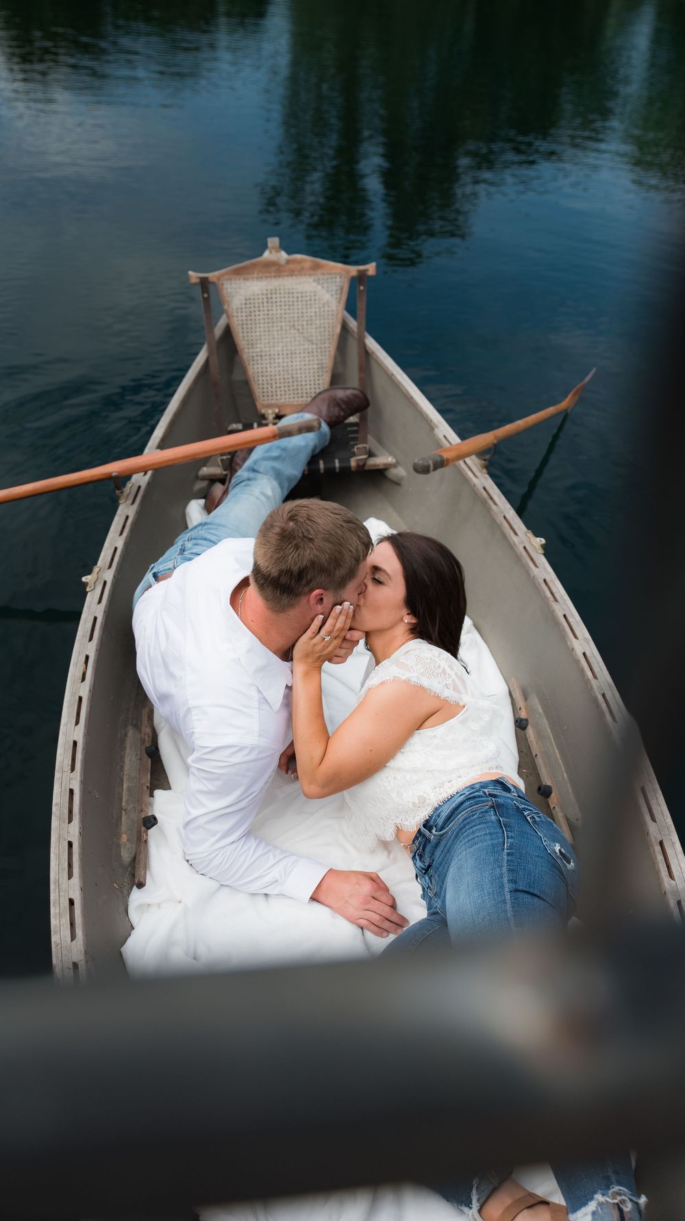 An engaged couple laying down kissing in a canoe in the pond at Whippoorwill Manor in Mayfield, KY.