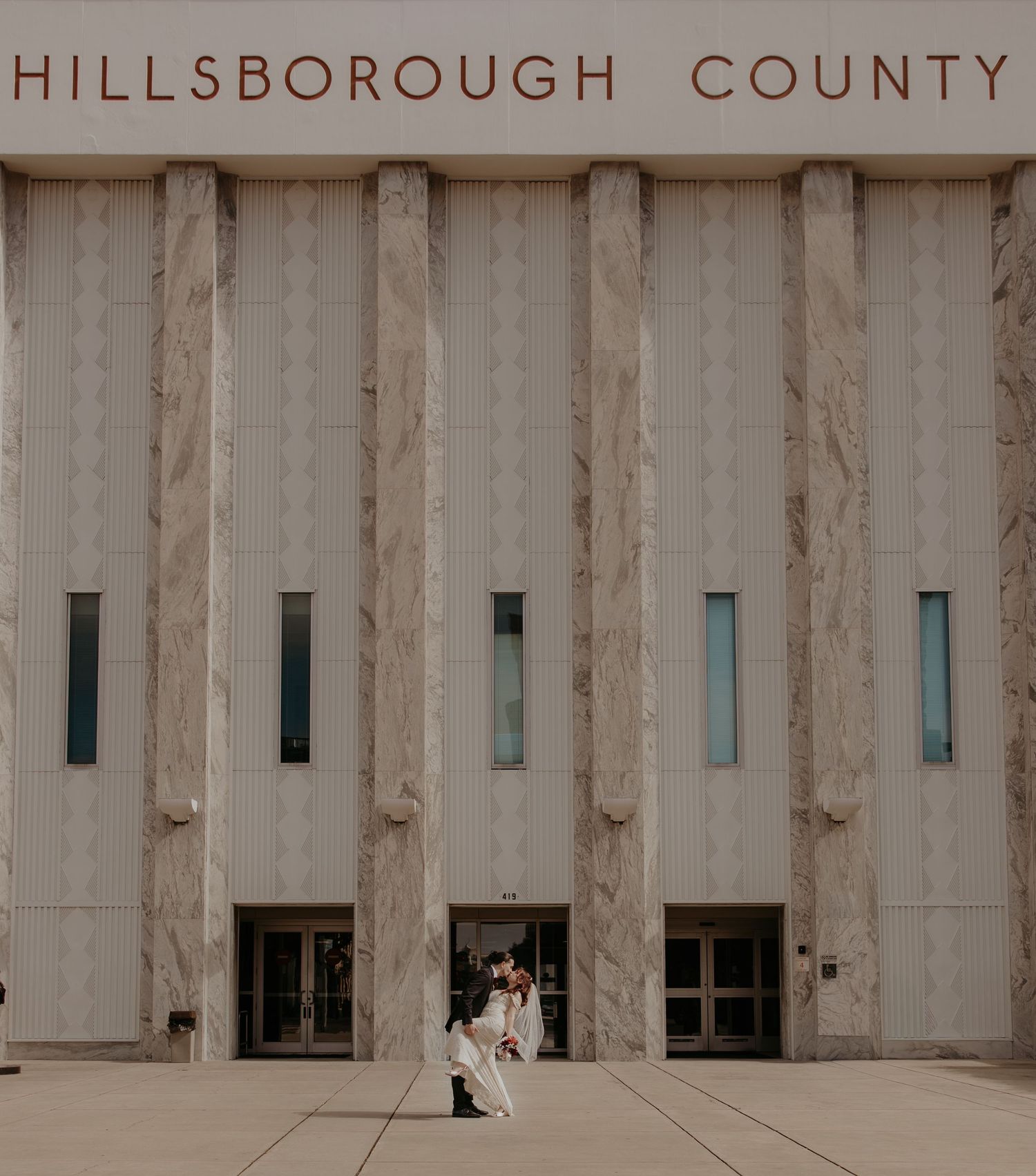 Outdoor wedding ceremony with dramatic storm clouds at sunset.