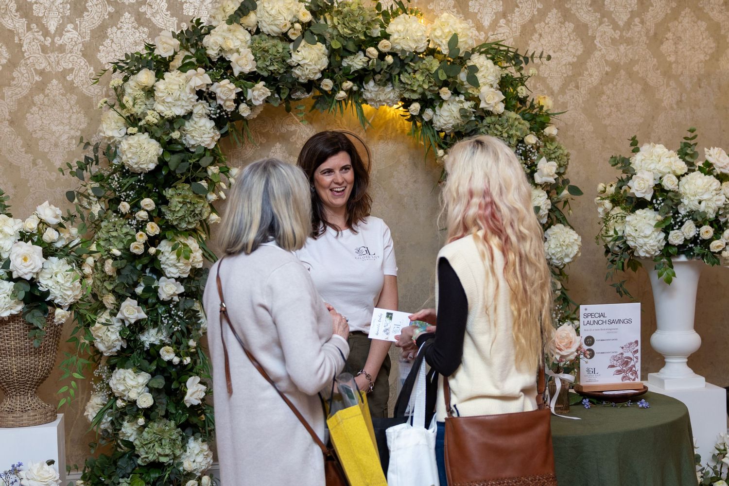 Elegant floral arrangements with white roses decorate an event space.