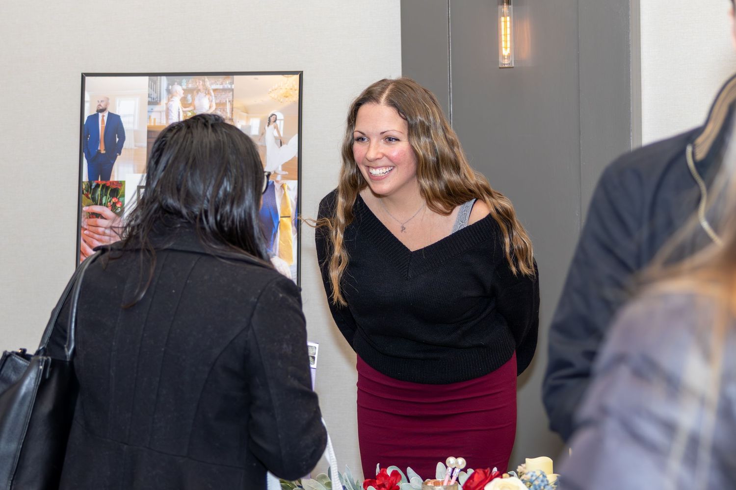 Vendor and attendee interact at a booth during an indoor event.