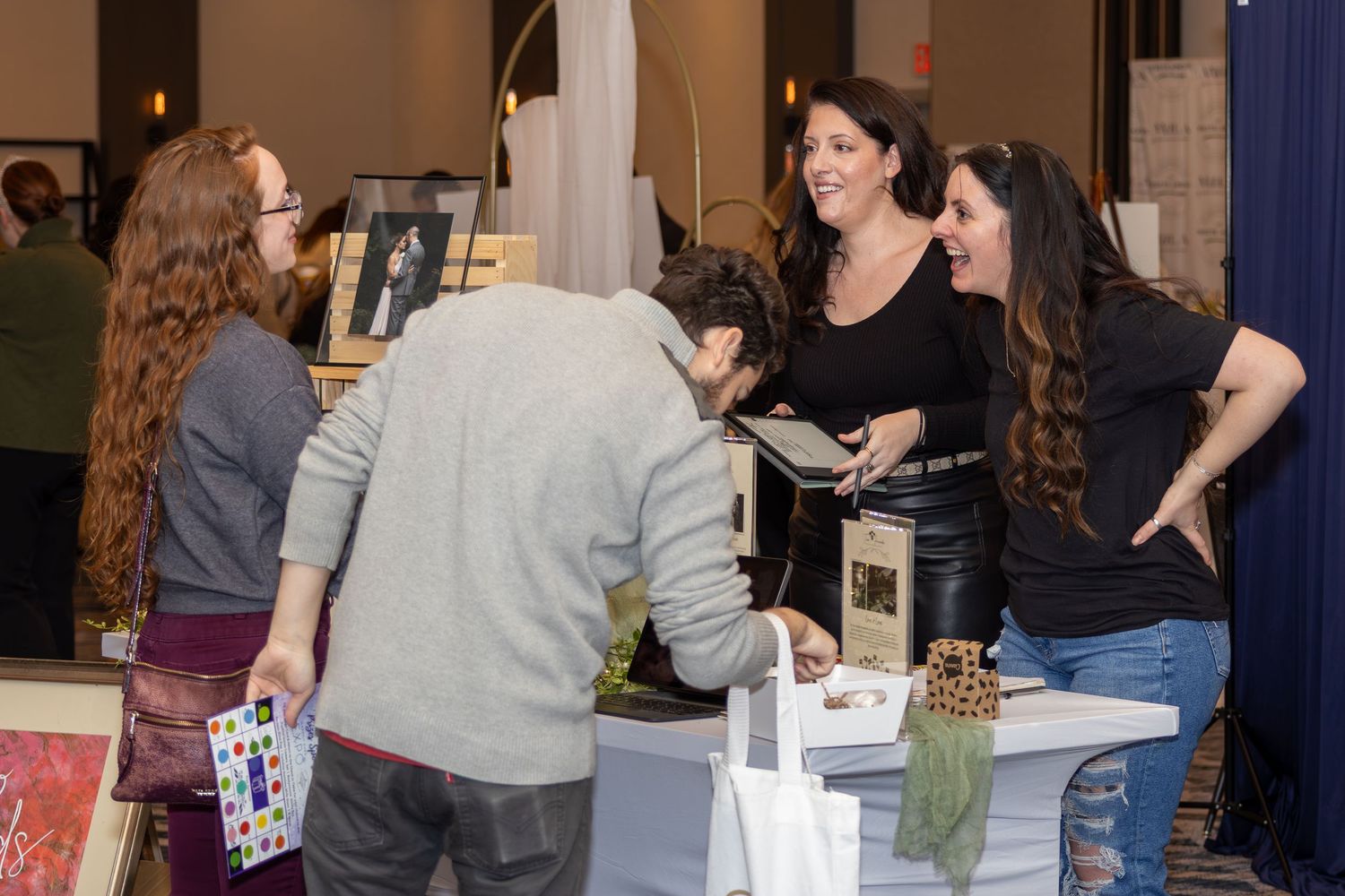 Attendees interact at a vendor booth during an event.