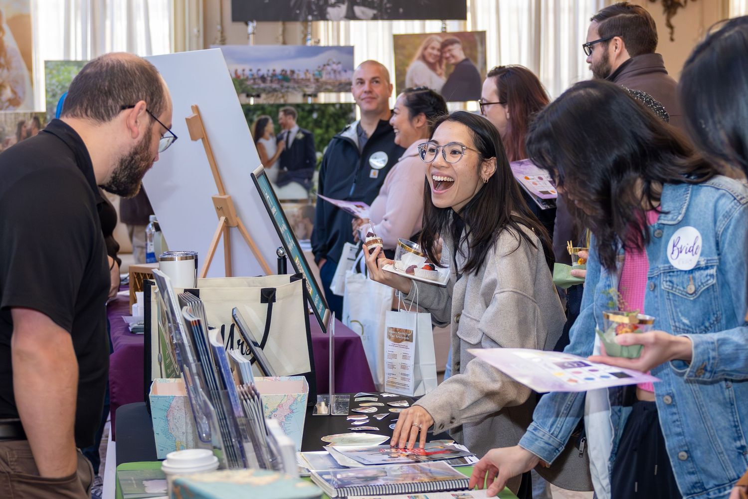 People interacting at a trade show or exhibition with various displays and booths.