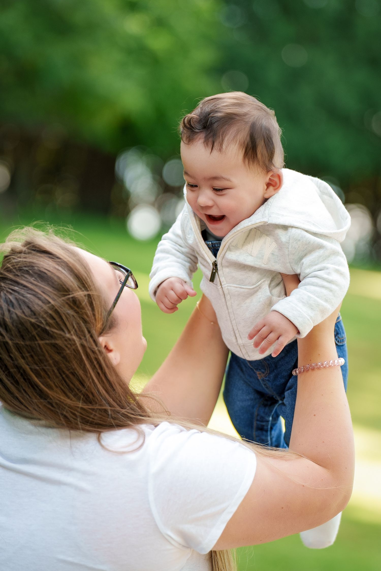 A tender moment captured in a series of photos showing parent and child playing together outdoors in a park setting.