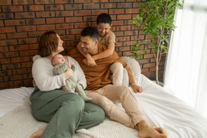 Intimate family portrait with brick backdrop and soft natural lighting.