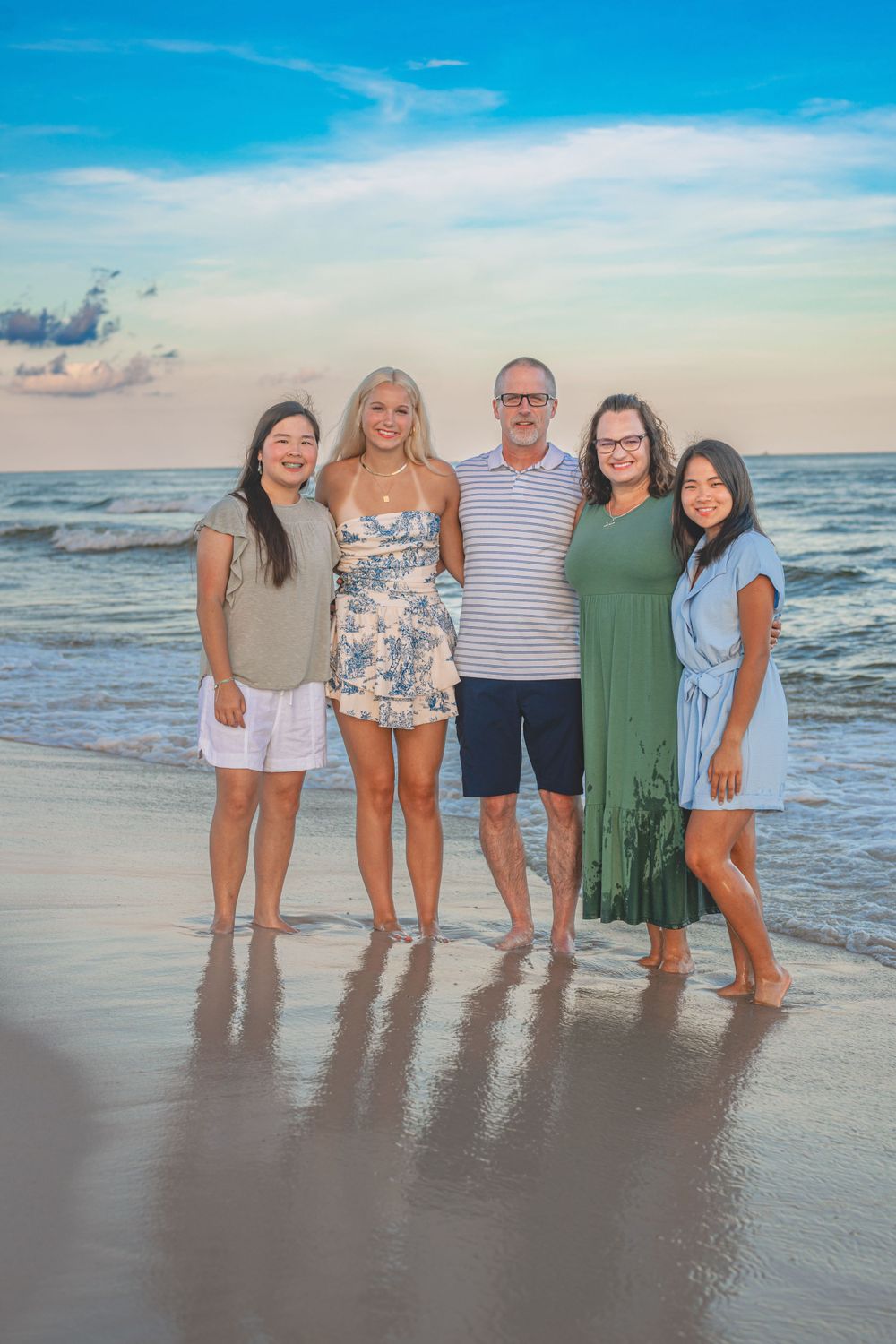 family beach sesion Gulf Shores Alabama Dad with Mom and teenage daughters Sunset waves and colors of the sky