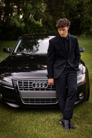 a young man in tux with car