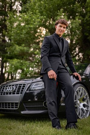 a young man in tux with car