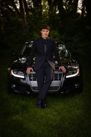 a young man in tux with car