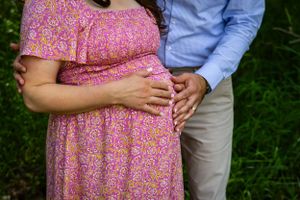 a couple with their hands on her baby bump.