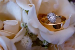 a gold ring and a diamond ring nestled in white roses.