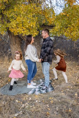 a family in front of a tree in autumn