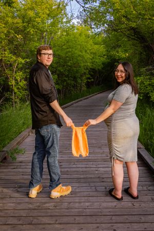 a couple holding a onesie.