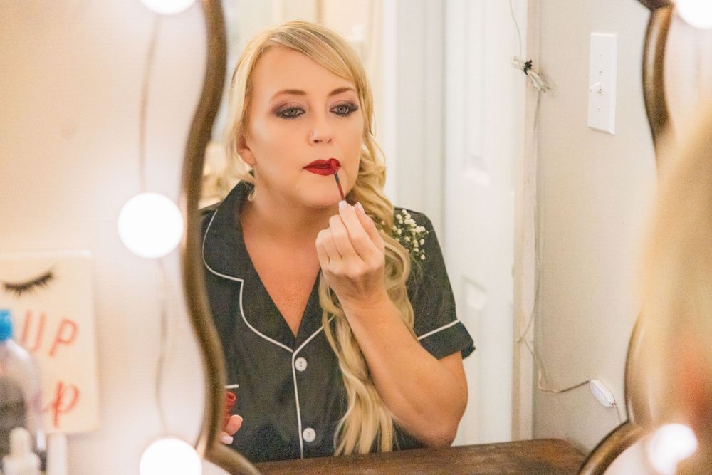 Wedding preparation scene with makeup application in dressing room.