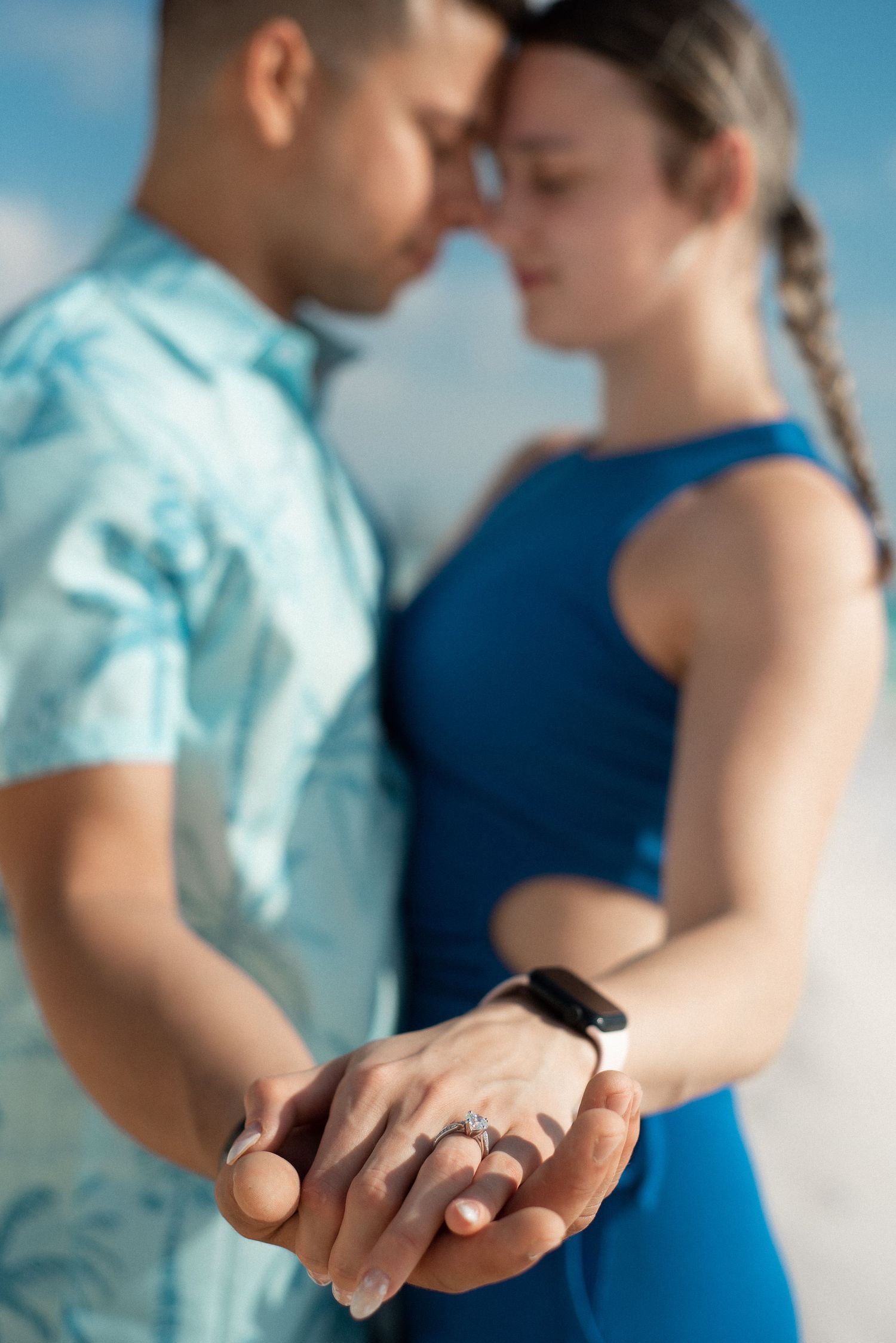 Portrait of a couple standing on the beach of Cancun, facing each other, forehead to forehead with their hands together