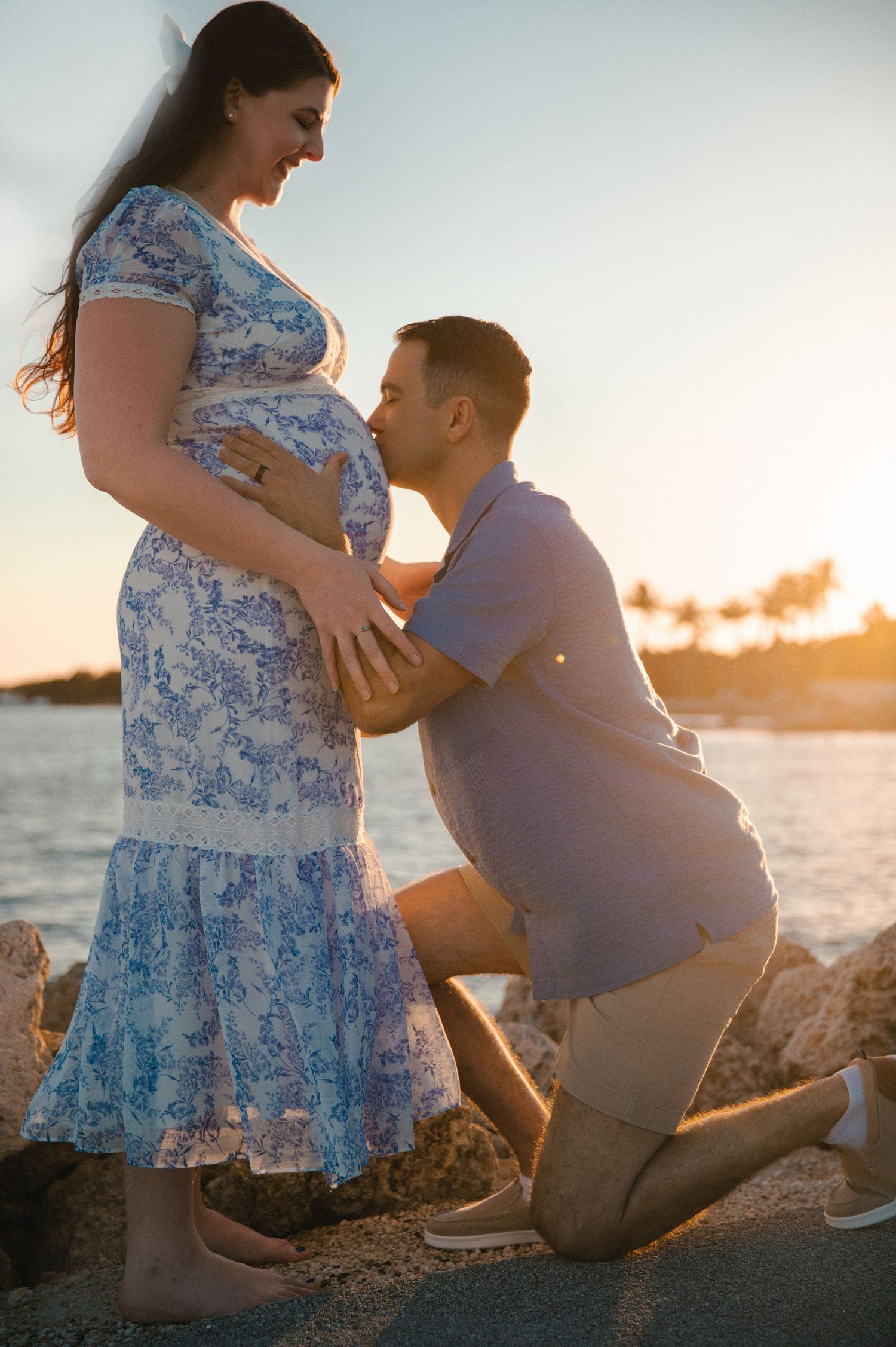 Sunset beach portrait with emerald green dress against wooden post.