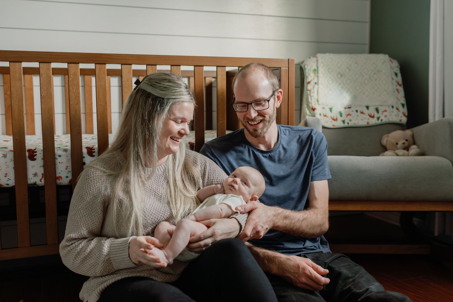 Tender moments between a baby and adults in a cozy nursery setting.