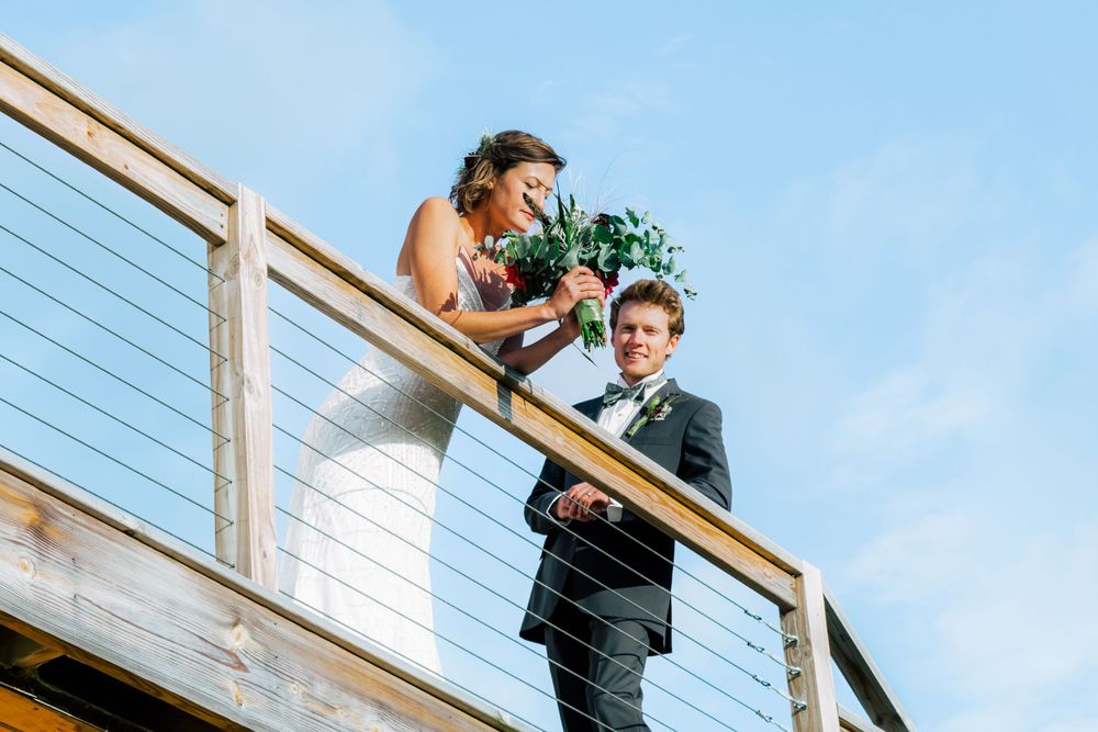 A series of people standing on a balcony with a blue sky background and modern railing design.
