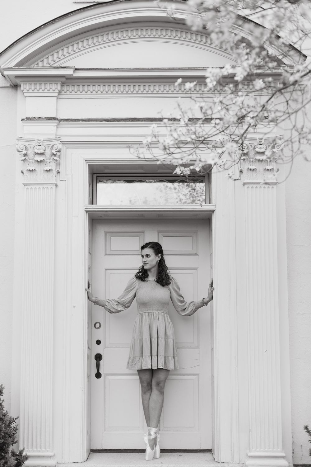 Artistic black and white series showing dancer posing against classical white doorway.