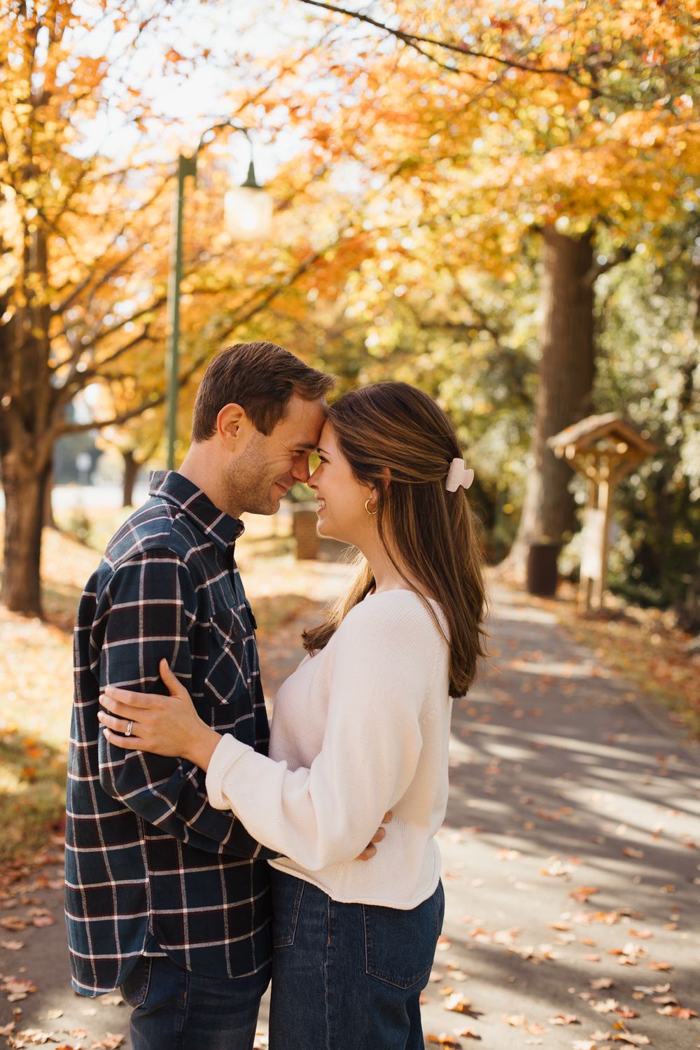 Romantic autumn couple photos with fall foliage and brick buildings in background.