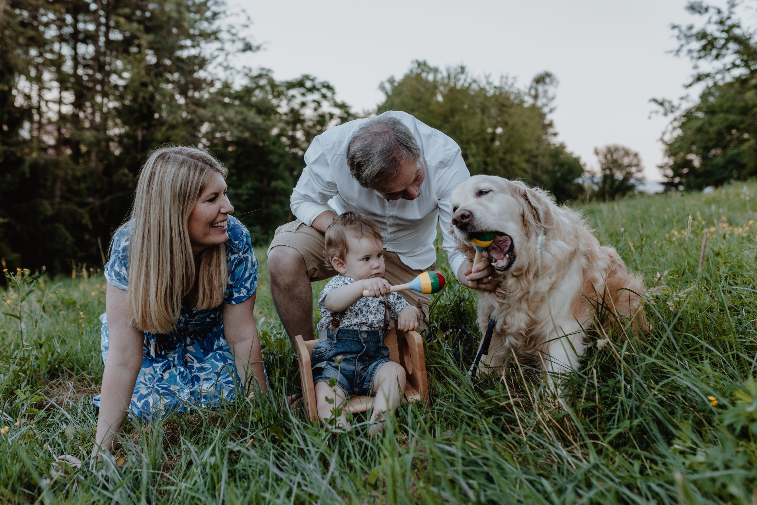 Family playing with a baby toy at Jelenovac, with the family dog joining in on the fun.