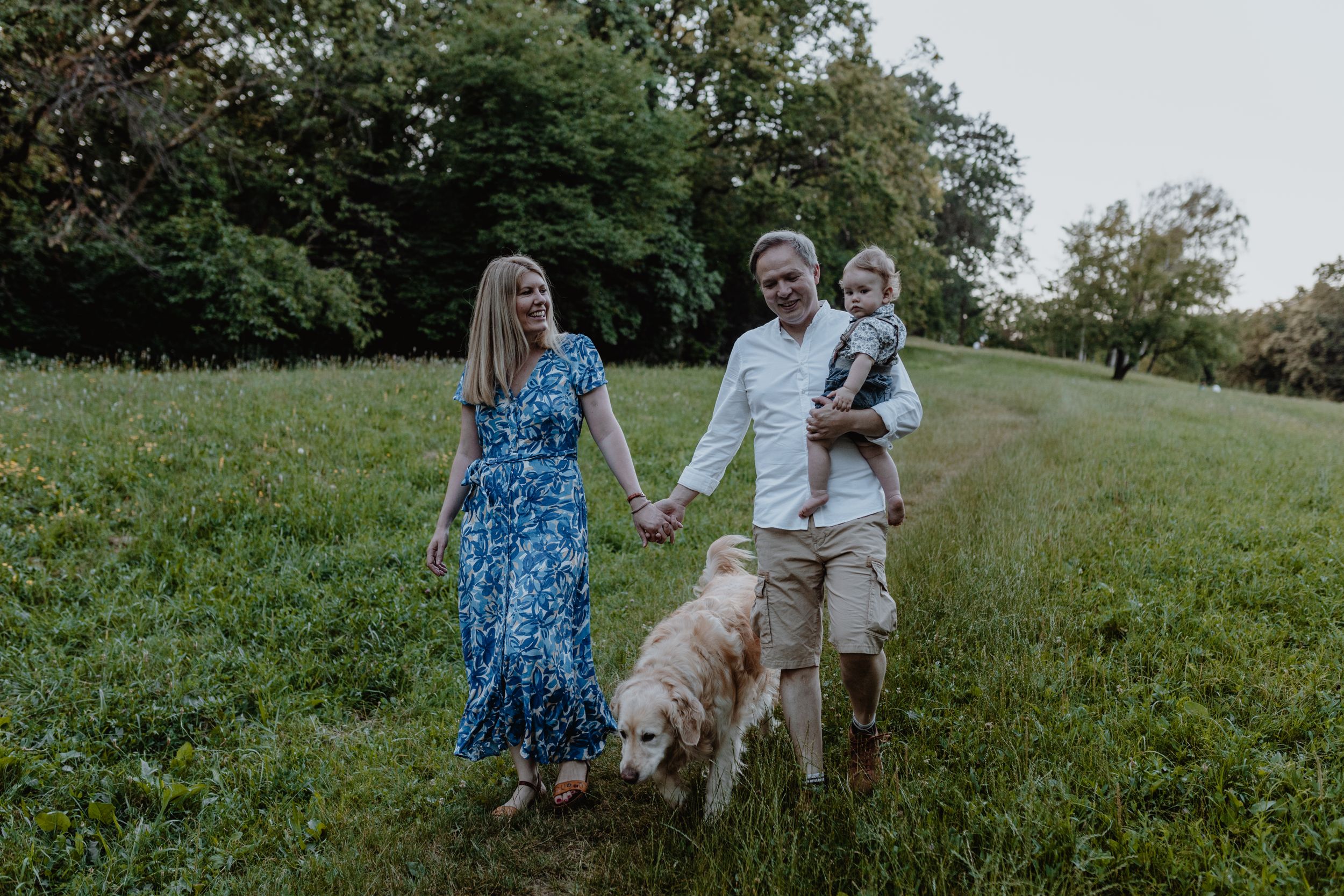 Parents and child celebrating a first birthday with a joyful walk at Jelenovac park.