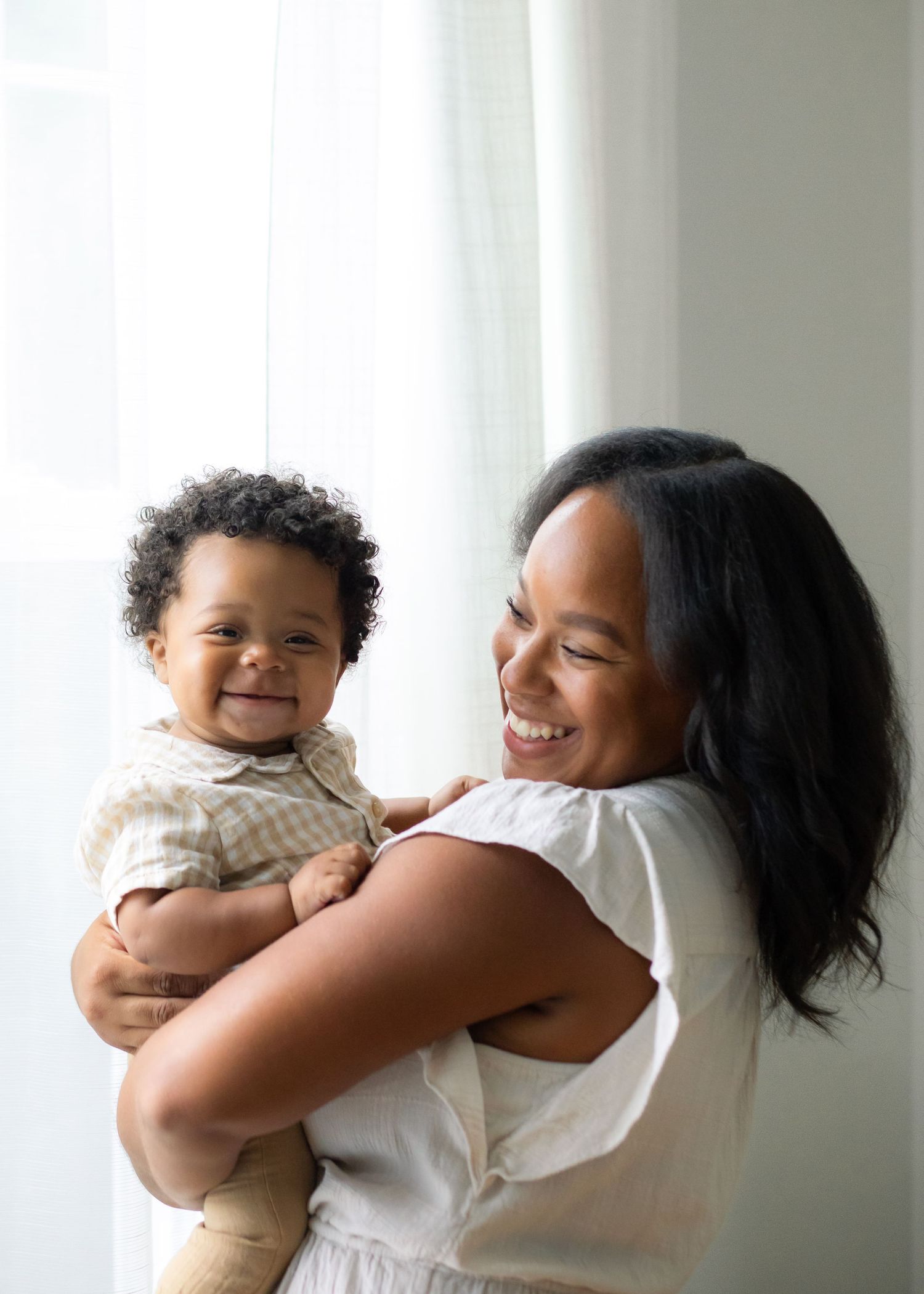A heartwarming sequence shows a mother and baby, her son, sharing a joyful embrace against a bright white background in Pawtucket, R.I. USA.