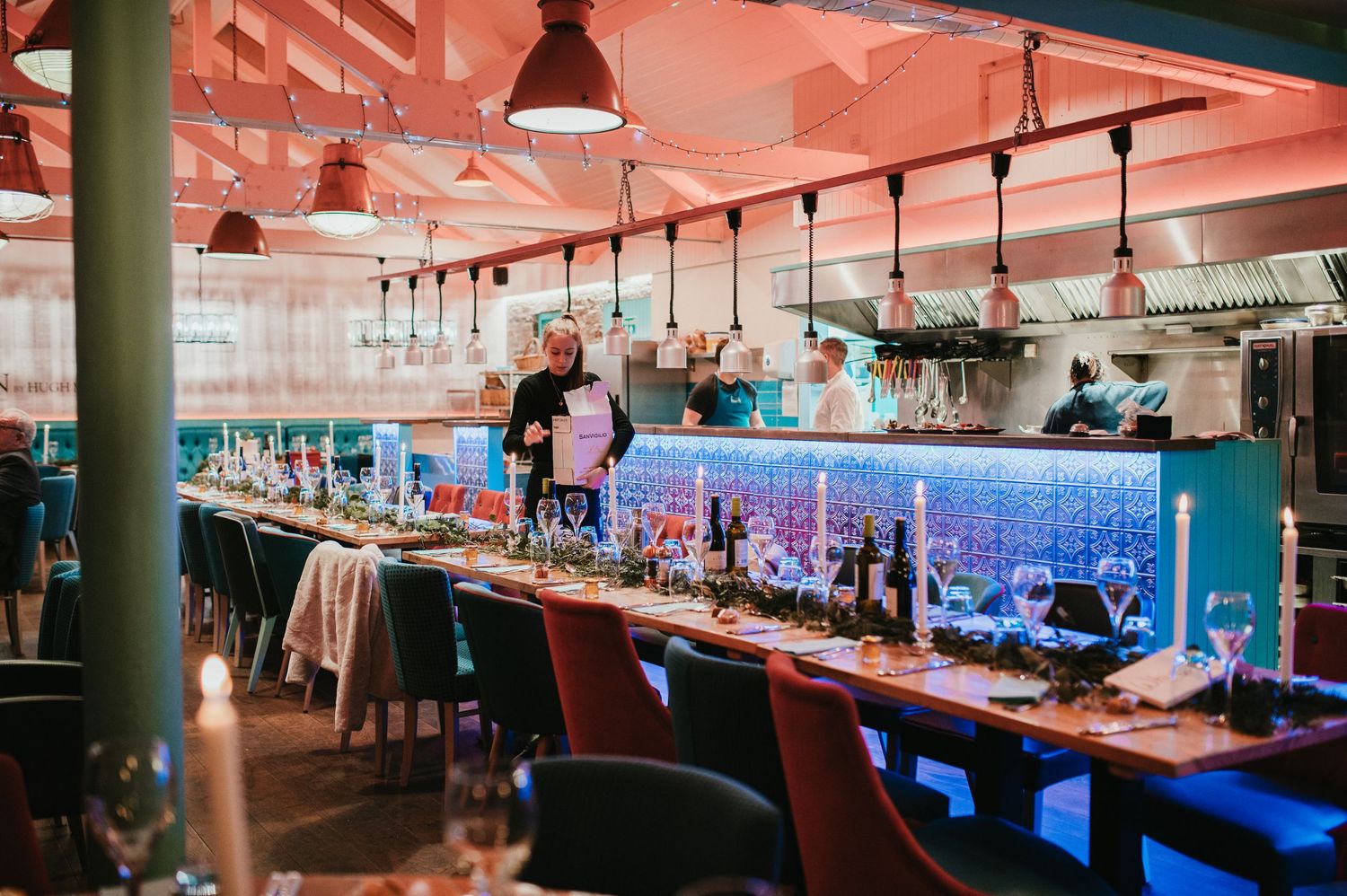 Modern bar setup with neon blue lighting and industrial-style pendant lamps.