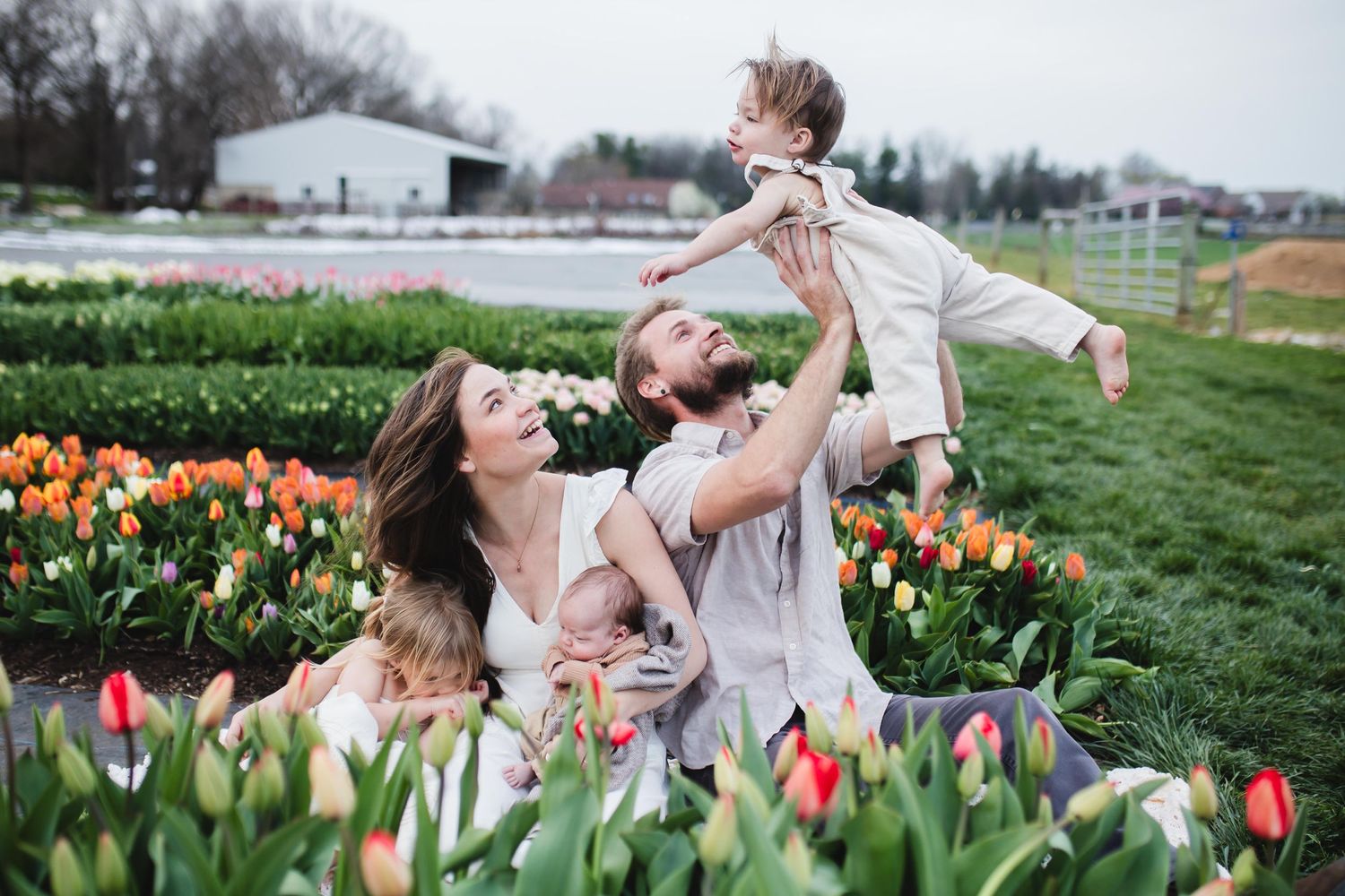 Joyful family moment captured in a vibrant tulip field during spring.