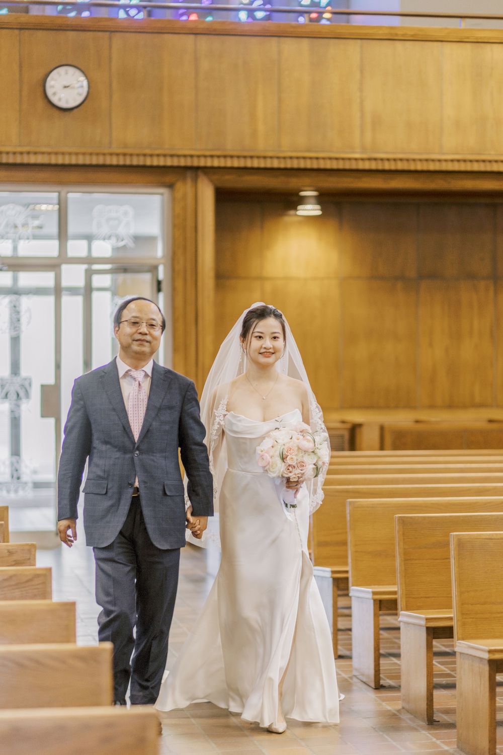Wedding ceremony processional in a church with wood paneled walls.
