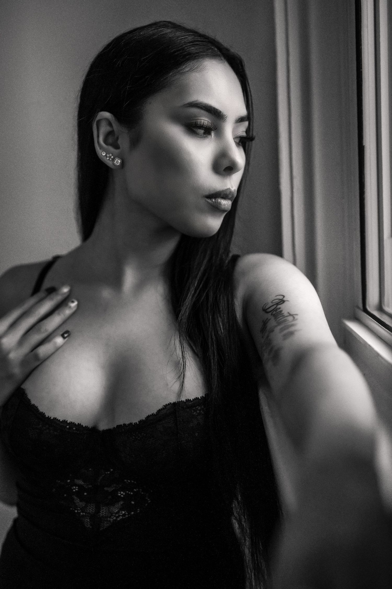 Dramatic black and white portrait photography with window lighting.