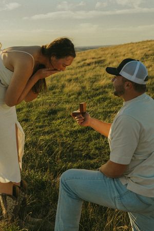 Friends relaxing on a grassy hillside during golden hour.