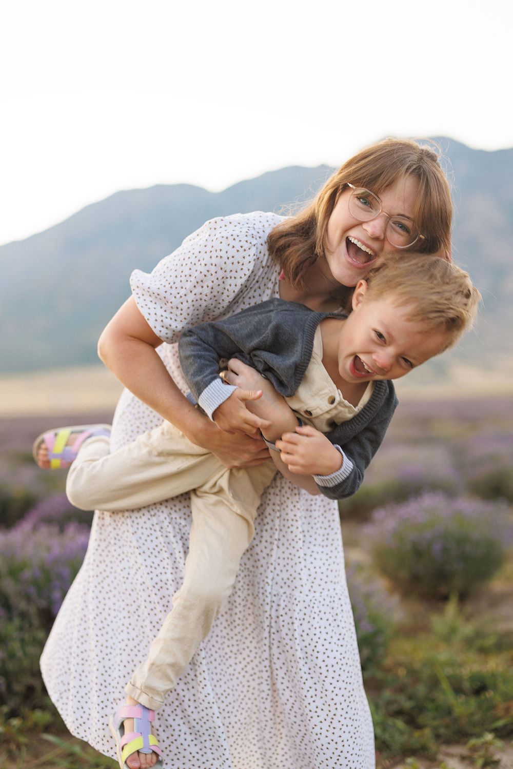 Mom and son hugging and smiling in field