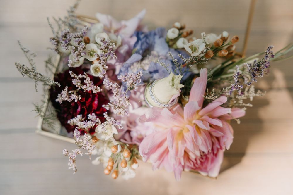 A romantic floral crown made with pink dahlias, deep burgundy flowers, and delicate baby's breath arranged in a circular design.