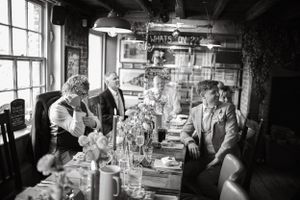 Rustic indoor wedding reception setup with vintage decor and table settings.