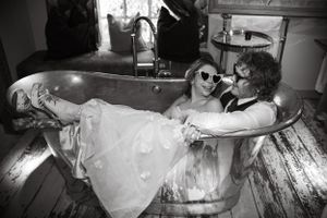 Black and white photo of wedding guests dancing and celebrating at a reception.