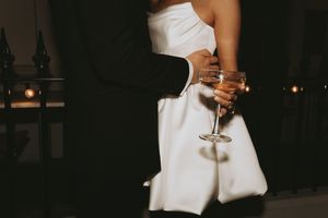 Elegant cropped shots of someone in a white dress holding champagne glasses at an evening event.