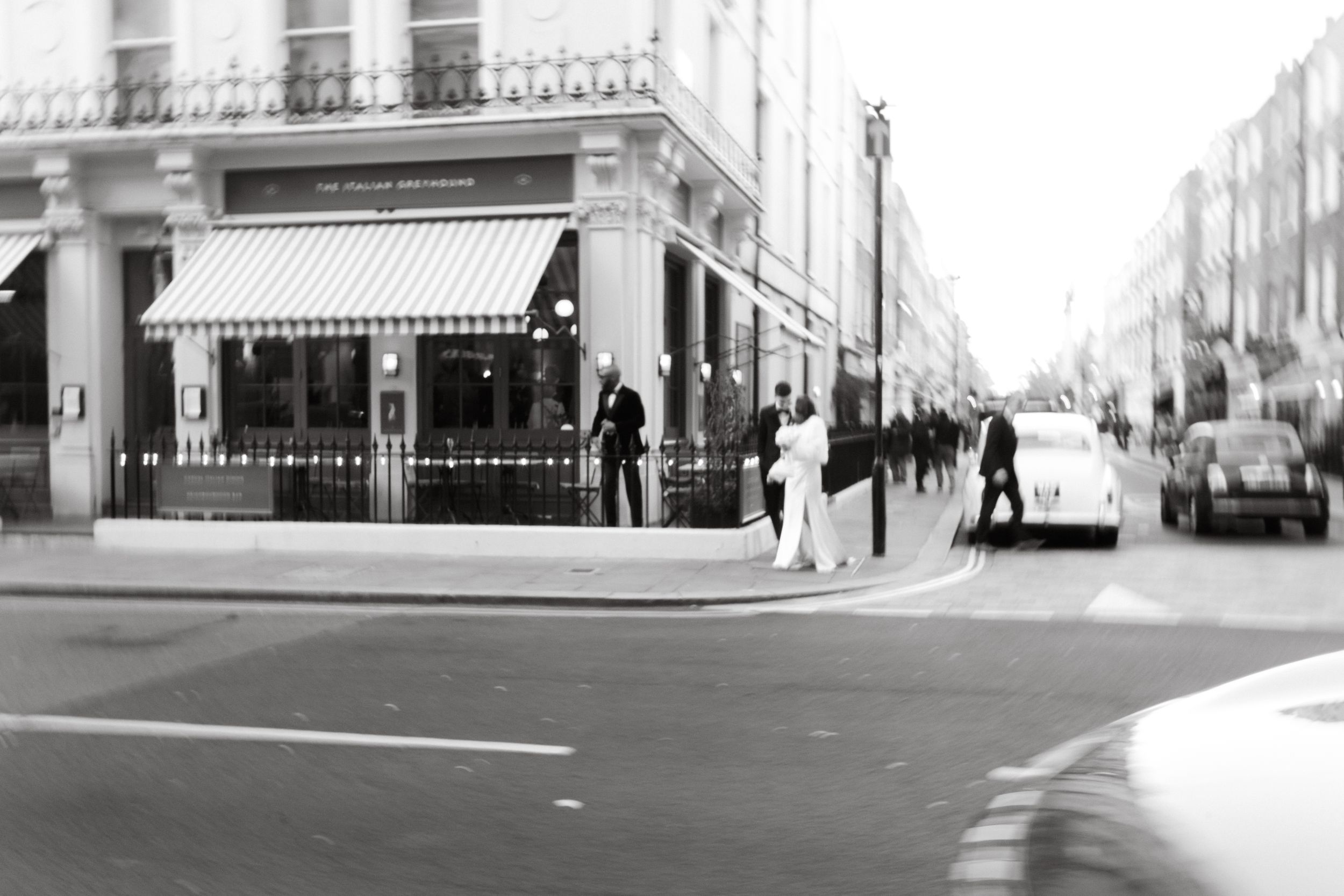 Black and white urban cityscape showing empty streets with historic architecture and storefronts.
